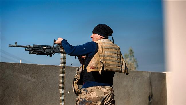 An Iraqi Army soldier fires his machinegun at Daesh positions in the northern city of Mosul