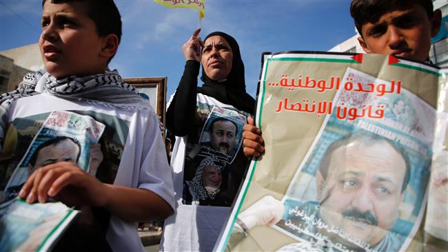 Palestinians hold portraits of prominent prisoner Marwan Barghouti, during a rally in the West Bank city of Ramallah in support of him and other prisoners on hunger strike in Israeli jails on April 24, 2017. (Photo by AFP)
