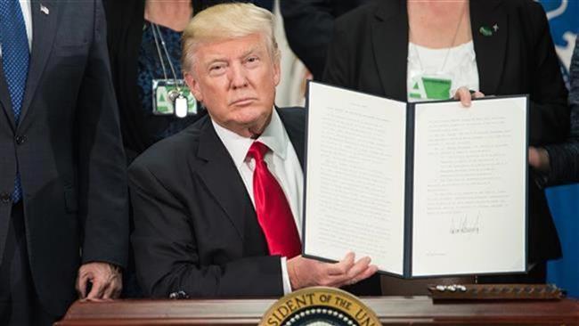 US President Donald Trump signs an executive order to start the Mexico border wall project at the Department of Homeland Security facility in Washington, DC, on January 25, 2017. (Photo by AFP)