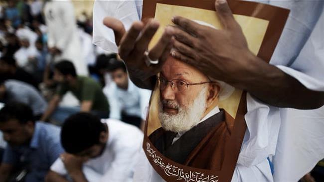 Bahrainis attend a protest against the revocation of the citizenship of top Bahraini Shia cleric Sheikh Isa Qassim (portrait), on June 20, 2016 near Qassim’s house in the village of Diraz. (Photo by AFP)