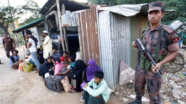 A security guard stands beside Rohingya Muslims illegally crossing at a border check point in Cox’s Bazar, Bangladesh, November 21, 2016. (Photo by Reuters)