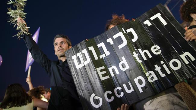 An Israeli protester holds a banner during a mass demonstration against 50 years of Israeli occupation in Tel Aviv on May 27, 2017. (Photo by AFP)