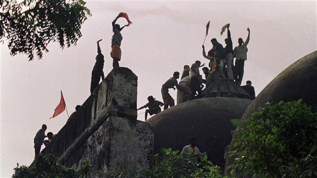 The photo taken on December 6, 1992 shows Hindu extremists shouting and waving banners as they stand on top of a stone wall and celebrate the destruction of the 16th century Babri mosque in Ayodhya, India. (Photo by AFP)