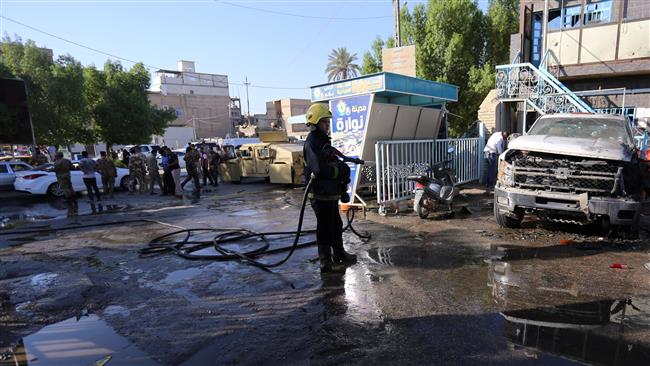 A firefighter hoses down a street after a terrorist bomb attack in the holy Iraqi city of Karbala on June 9, 2017. (Photo by Reuters)