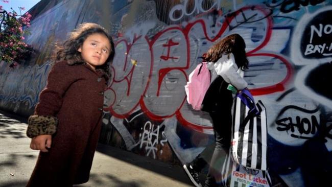 Three year old Saria Amaya (L) waits with her mother after receiving shoes and school supplies during a charity event to help more than 4,000 underprivileged children at the Fred Jordan Mission in the Skid Row area of Los Angeles. (Photo by AFP)