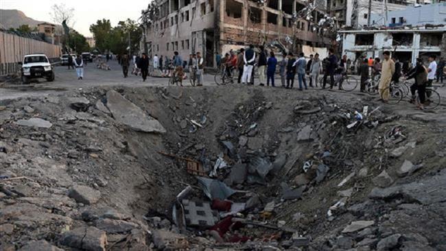 Afghan security forces and residents stand near the crater left by a truck bomb attack in Kabul on May 31, 2017. (Photo by AFP)