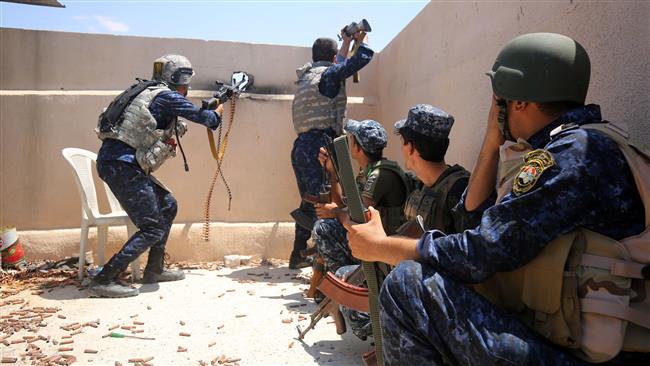 Iraqi forces take position on the roof of a building as they advance towards Mosul
