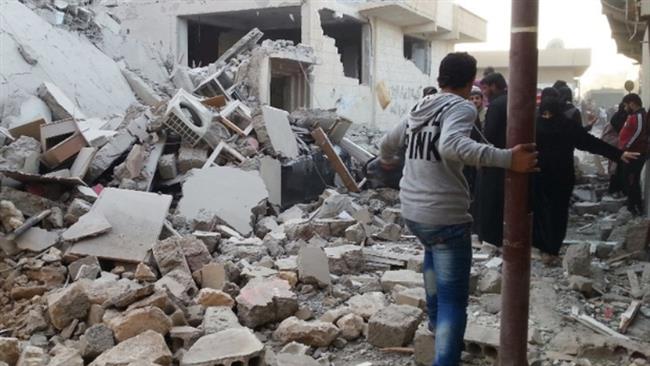 People walk past a building reportedly targeted by US warplanes in the Syrian city of Raqqah. (Photo by AFP)