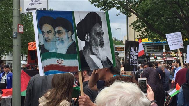 Pro-Palestinian activists rallying in Berlin, Germany, on the occasion of the International Quds Day hold up placards bearing the Iranian flag and portraits of the late founder of the Islamic Republic, Imam Khomeini, and Leader of the Islamic Revolution Ayatollah Seyyed Ali Khamenei, June 23, 2017.