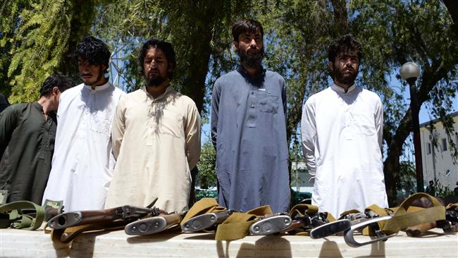 Suspected Daesh members stand next to weapons as they are presented to the media at the police headquarters in Jalalabad, Afghanistan, May 29, 2017. (Photo by AFP)