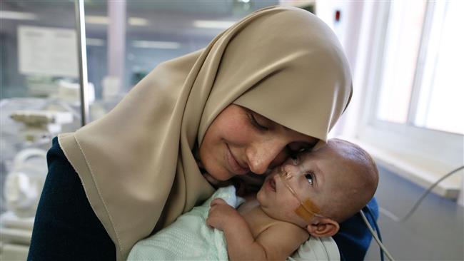 Gazan Jumana Daoud carries her 7-month-old daughter Maryam at Makassed Hospital in the occupied east Jerusalem al-Quds, February 20, 2017. (Photo by AFP)