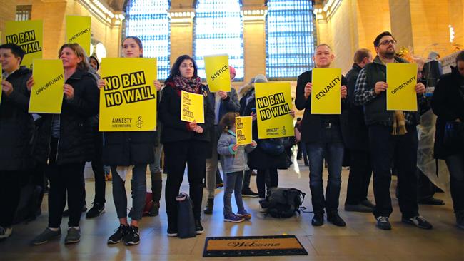 People stand holding placards as they take part in a protest called No Ban! No Wall! Get Loud, hosted by Amnesty International USA, inside Grand Central Station in New York City ,on March 3, 2017. (AFP photo)