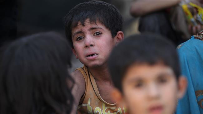 An Iraqi child gazes as he sits for a rest, while fleeing from the Old City of Mosul on July 5, 2017. (Photo by AFP)
