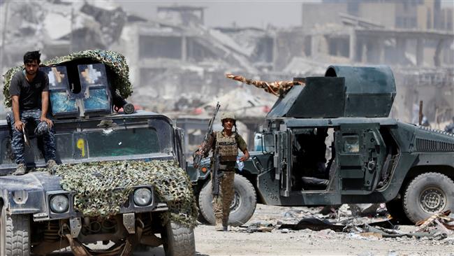Iraqi security forces carry their weapons during fighting with Daesh militants in Mosul