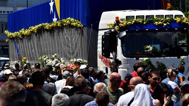 Bosnian Muslims stand next to a truck carrying caskets of Srebrenica 1995 massacre victims, July 9, 2017, Sarajevo. (Photo by AFP)