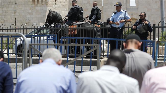 Israeli forces stand guard as Muslim worshippers pray outside the Damascus Gate, a main entrance to the Old City of Jerusalem al-Quds, on July 14, 2017, after the al-Aqsa Mosque was closed for Friday prayers by Israeli authorities following a shootout. (Photo by AFP)