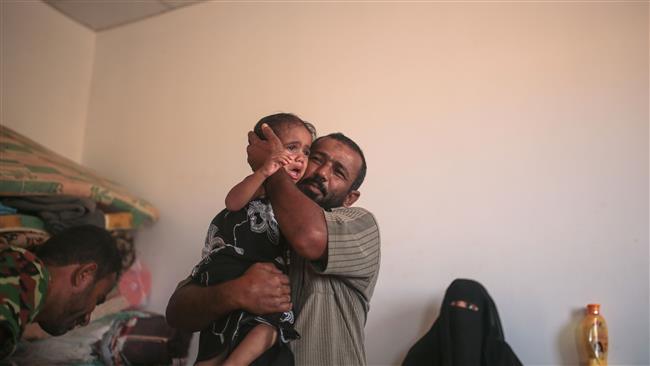 A Yemeni refugee comforts his daughter in an under-construction orphanage that has been turned into a transit center for Yemeni refugees, in northern Djibouti on May 19, 2015. (AP photo)