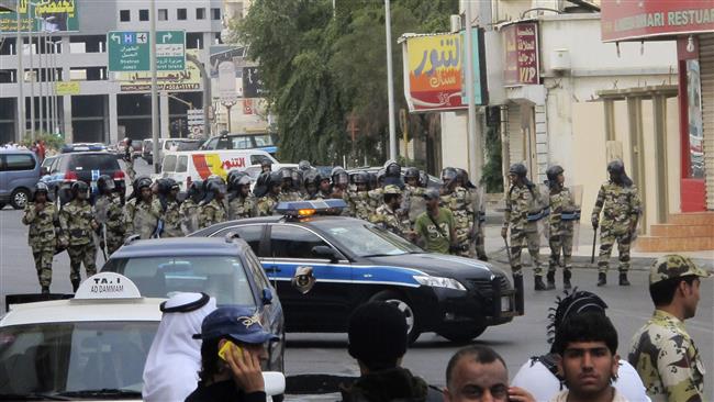 Saudi police gather as Shia protesters, unseen, chant slogans during a demonstration in Qatif, Saudi Arabia, March 11, 2011. (Photo by AP)