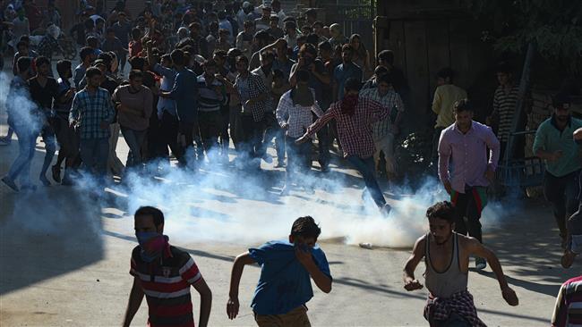 Kashmiri Muslims run after Indian government forces fired tear smoke shells during the funeral of Tanveer Ahmed Pala in Beerwah town in the central Kashmir’s Budgam district on July 21, 2017. (Photo by AFP)