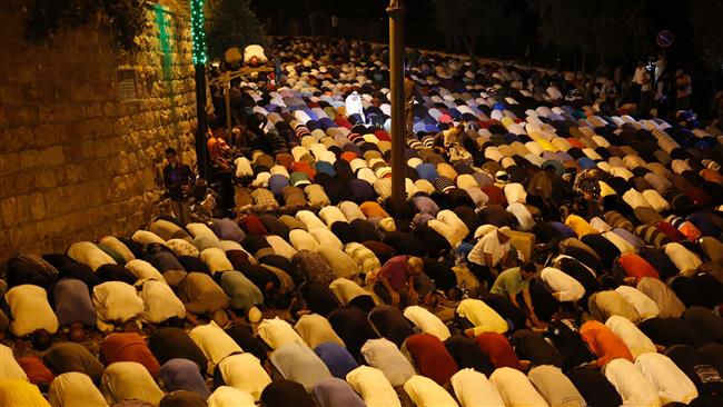 Palestinian worshippers pray outside the Al-Aqsa compound in Jerusalem