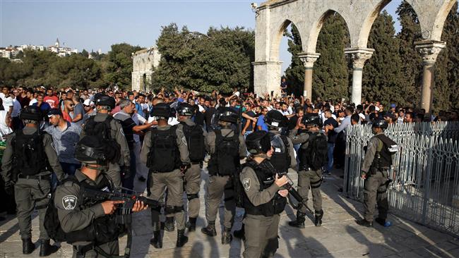 Palestinian Muslims raise their arms and shout slogans before Israeli forces at the al-Aqsa Mosque compound in the occupied Old City of Jerusalem al-Quds on July 27, 2017. (Photo by AFP)