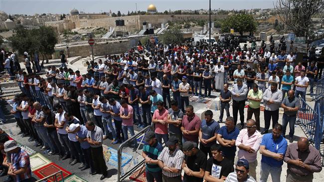 Palestinian Muslim worshipers pray outside the Old City of Jerusalem al-Quds overlooking the al-Aqsa Mosque compound on July 28, 2017. (Photo by AFP)