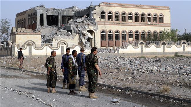 Yemenis walk past a building, housing branches of the Finance Ministry and Central Bank, that was heavily damaged in an airstrike in the northern province of Sa’ada on July 24, 2017. (Photo by AFP)