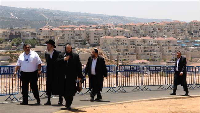 Ultraorthodox Israelis walk at the site of a groundbreaking ceremony for a new neighborhood in the Beitar Illit settlement, in Tel Aviv-occupied West Bank, August 3, 2017. (Photo by AFP)
