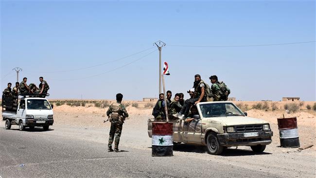 A picture taken on July 8, 2017 shows members of the Syrian pro-government forces riding in vehicles on the road near the Syrian village of Hanna Safar on the western outskirts of Raqqah Province. (Photo by AFP)