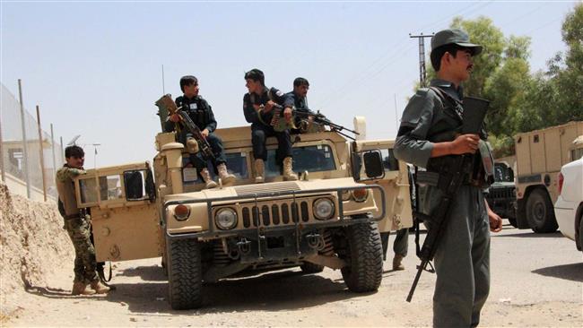 Afghan security personnel sit on atop an armored vehicle amid an ongoing battle with Taliban militants in the Gereshk district of Helmand province on July 22, 2017. (Photo by AFP)