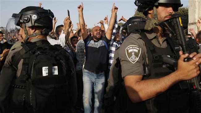 A Palestinian raises his arms and shouts slogans before Israeli forces in the Haram al-Sharif compound, in the old city of Jerusalem al-Quds on July 27, 2017. (Photo by AFP)