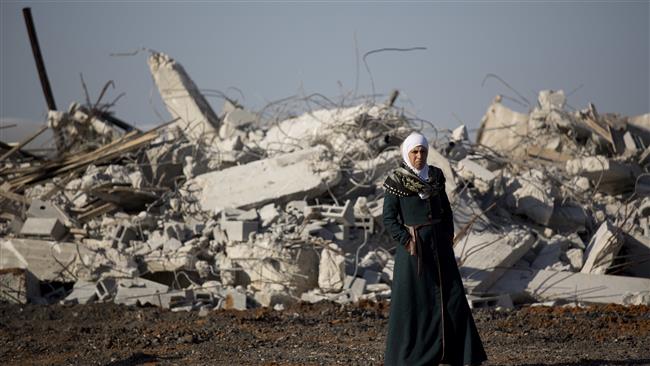 A Palestinian woman stands by the rubble of demolished house in Kalansua in the occupied Palestinian territories on January 11, 2017. (Photo by AP)