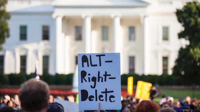 A demonstrator holds a sign in front of the White House on August 13, 2017 in Washington, DC. (Photo by AFP)