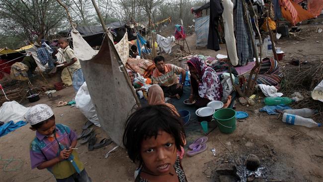 The file photo shows a Rohingya family eating their breakfast at a makeshift shelter in a camp in New Delhi, India. (Photo by Reuters)
