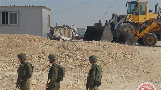 Israeli forces watch as Tel Aviv regime bulldozers demolish UN funded homes in a Bedouin village in the southern West Bank. (Photos by Ma’an)