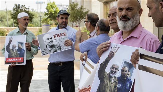 Supporters of Sheikh Raed Salah (portrait), the leader of the northern branch of the Islamic Movement in Israel, gather in protest against his arrest and detention, outside the Israeli Rishon Lezion magistrate court, near Tel Aviv, on August 17, 2017. (Photo by AFP)
