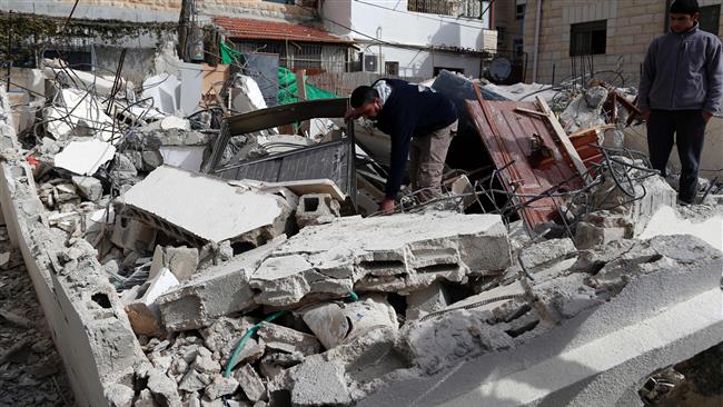 A Palestinian man gathers his belongings outside his house that was demolished by Israeli army bulldozers in occupied East Jerusalem al-Quds on February 22, 2017. (Photo by AFP)