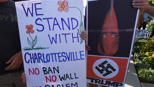 Anti-Trump demonstrators hold protest signs during a rally to support Democratic Congressman Brad Sherman