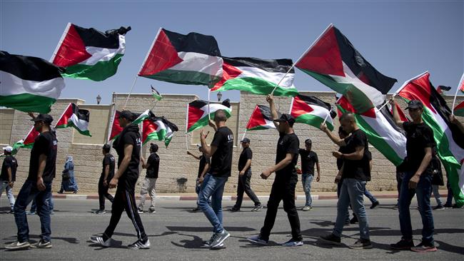 Palestinians carry national flags as they stage a rally to mark the 69th anniversary of the Nakba Day (the Day of Catastrophe) in the West Bank city of Ramallah on May 15, 2017. (Photo by AP)