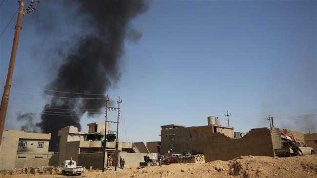 Smoke billows in the background as the Iraqi forces, backed by the Popular Mobilization Units (PMU), commonly known as Hashd al-Sha’abi, advance inside al-Nour neighborhood, in eastern Tal Afar, Iraq, August 23, 2017. (Photo by AFP)