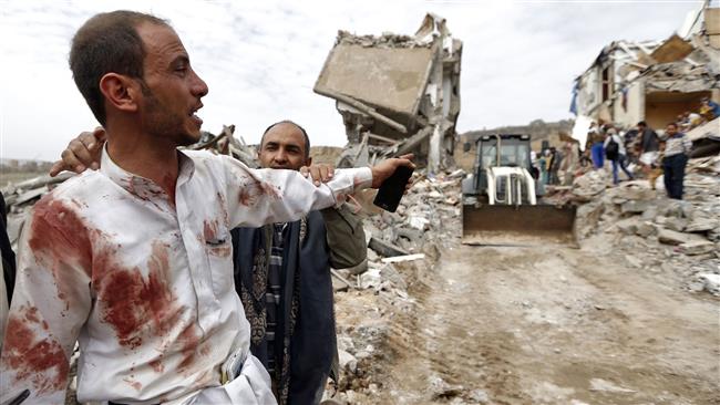 A Yemeni man covered in blood stains reacts as people search for survivors in the debris of buildings hit in an airstrike in the residential southern district of Faj Attan in the capital Sana