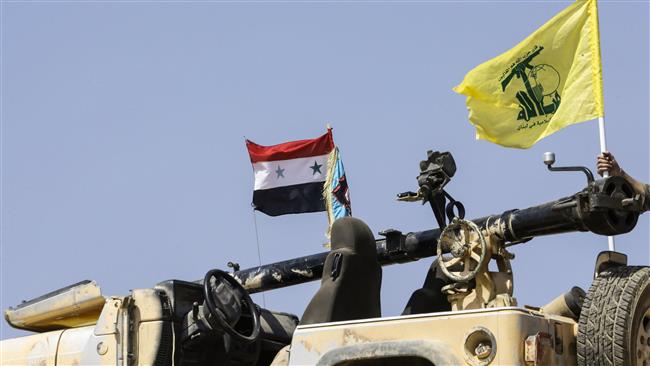 A picture taken on August 2, 2017 during a tour guided by the Lebanese resistance movement of Hezbollah shows the flags of the movement (R) and the Syrian national flag flying on a four-wheel drive vehicle, at a position in a mountainous area around the Syrian town of Flita near the border with Lebanon. (Photo by AFP)