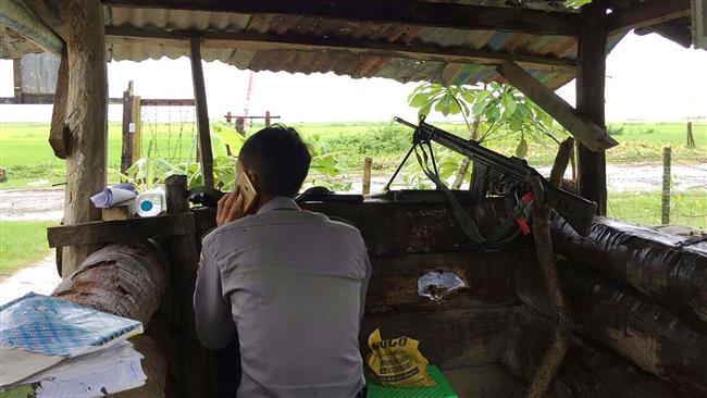 A Myanmar policeman talks on the phone as he mans a checkpoint at the entrance of Yathae Taung town in Rakhine state in Myanmar, August 26, 2017. (Photo by AFP)