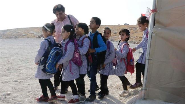 Teachers instruct children to stand in line before class begins at Jub El-Thib, east of Bethlehem, the occupied West Bank, on August 28, 2017, a few days after Israeli authorities demolished their newly constructed school.