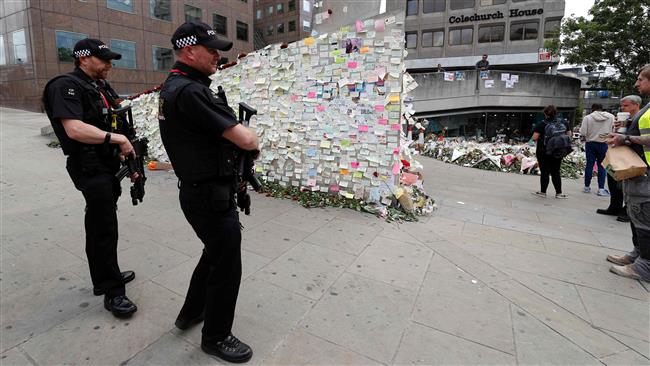 Armed police officers stop to look at messages left by well-wishers on London Bridge in London on June 12, 2017, following the June 3 terrorist attack. (Photo by AFP)