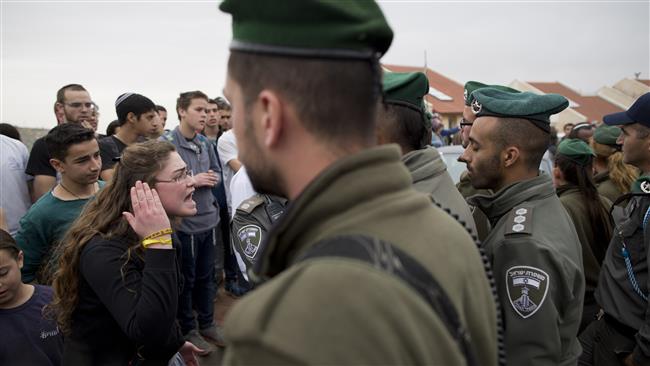 An Israeli settler argues with police in the West Bank settlement of Ofra on February 28, 2017 as the regime forces begin evacuating their structures following a court decision. ( Photo by AP)