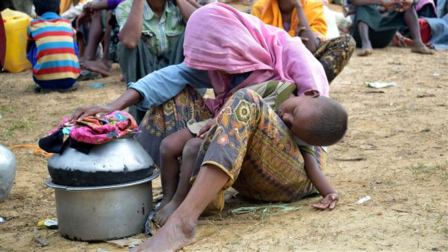 This August 29, 2017 photo shows an elderly Rohingya refugee holding her sleeping grandson in her lap at the Kutupalong refugee camp in Ukhiya, after crossing the border from Myanmar into Bangladesh. (By AFP)
