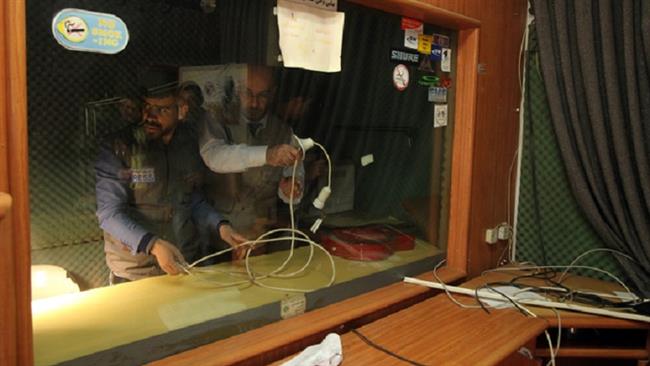 Palestinian journalists check the damage after Israeli soldiers raided the offices of a local Palestinian radio station in Hebron (al-Khalil) on 21 November 2015. (Photo by AFP)