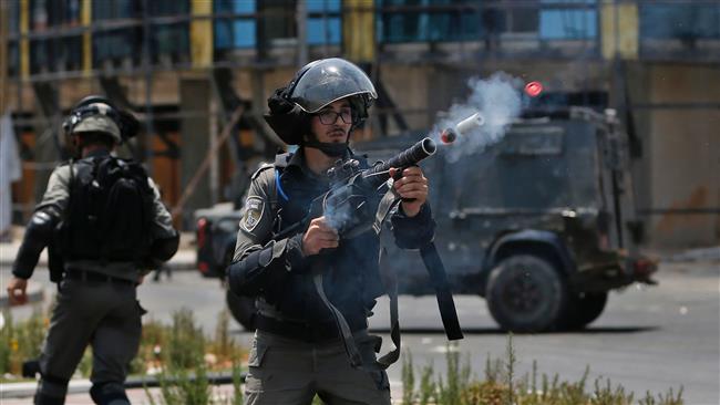 An Israeli border guard fires a teargas canister towards Palestinian protesters during clashes near the settlement of Beit El, near the occupied West Bank city of Ramallah, on July 24, 2017. (Photo by AFP)