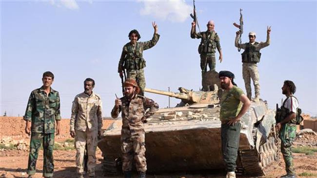 Syrian pro-government forces flash the victory sign on top of a tank after taking control of the northern Syrian town of Maskanah from Daesh terrorists on June 5, 2017. (Photo by AFP)